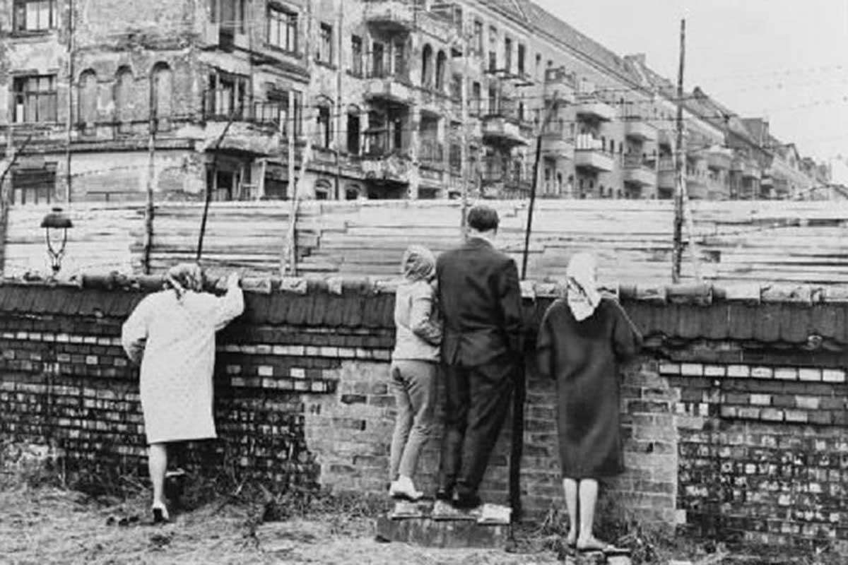 Группа западных немцев выглядывает из-за стены в 1962 году. Источник: (Библиотека Конгресса/Pinterest).